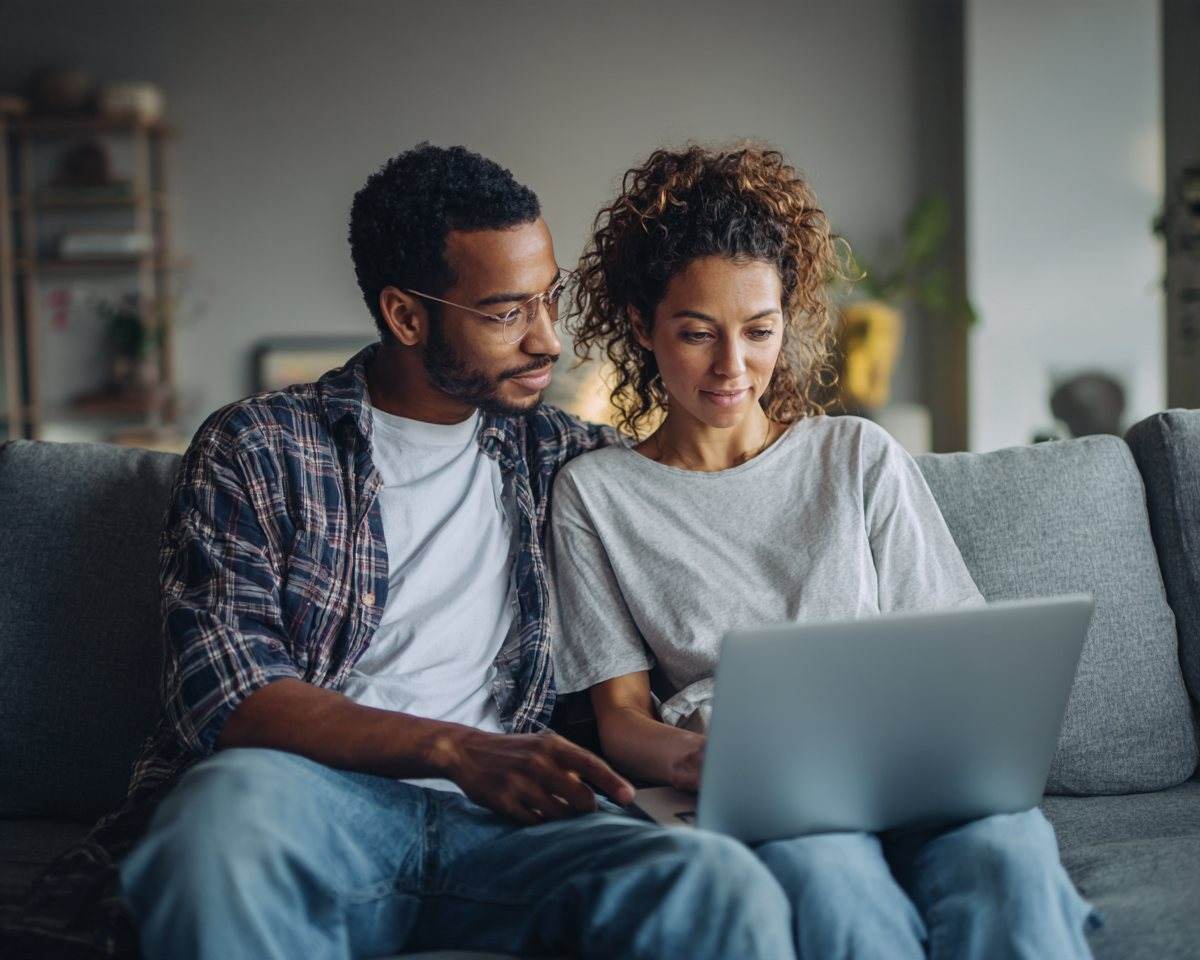 A couple on the sofa looking at results together on a laptop